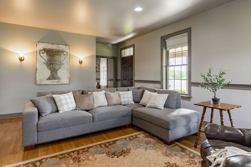 Living room opens to a kitchen bar with a gray sectional and bistro seating