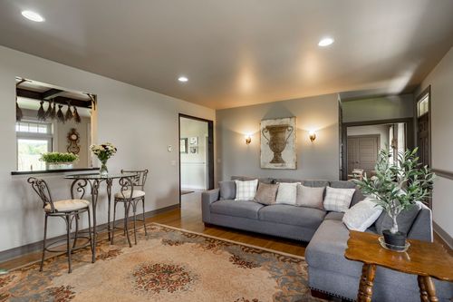 Dining room with a wood table, chandelier and gallery wall of framed photos