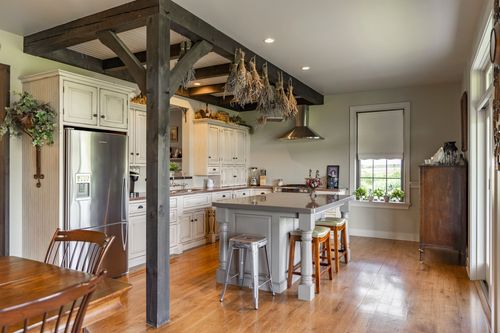 Farmhouse kitchen with dried herb bundles hanging from a wood beam ceiling