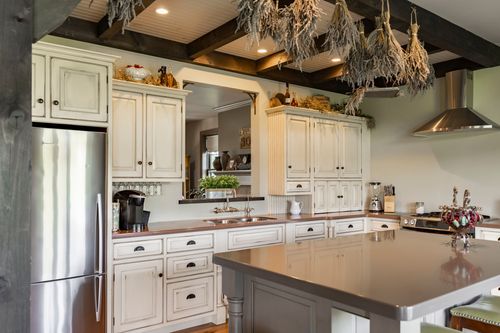 Kitchen with bundles of dried herbs hanging above white cabinetry