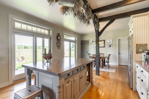 Farmhouse kitchen with French doors and dried herbs hanging from the beams