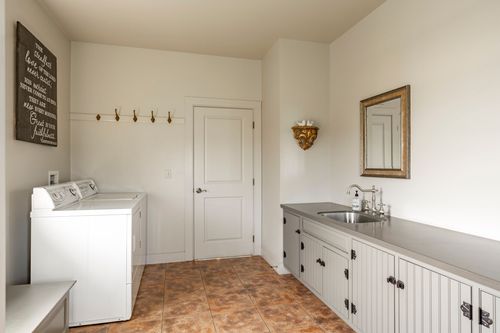Laundry room with coat hooks, a washer and a sink at the far end