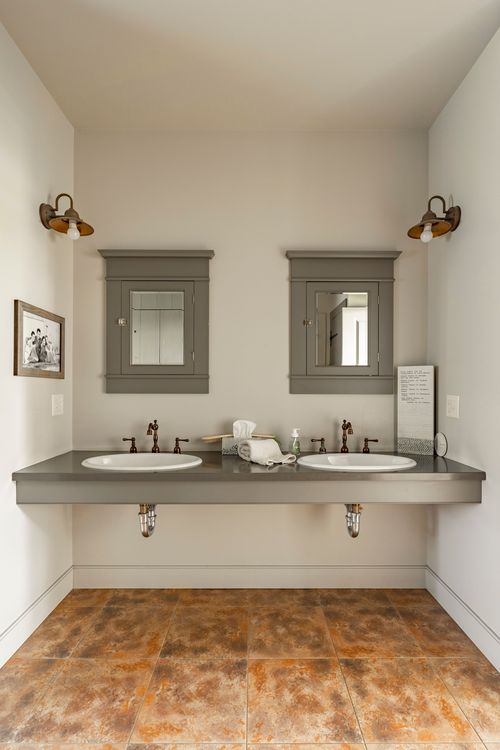 Symmetrical double vanity bathroom with mirrored cabinets and sconces