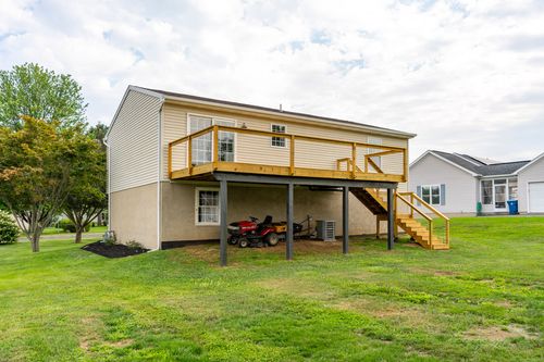 Rear exterior with a covered carport beneath an elevated deck