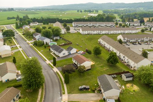 Aerial view of a ranch-style home with a wraparound deck