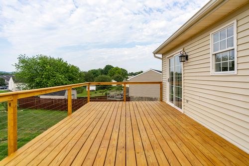 Wood deck corner with a sliding glass door and wall sconce