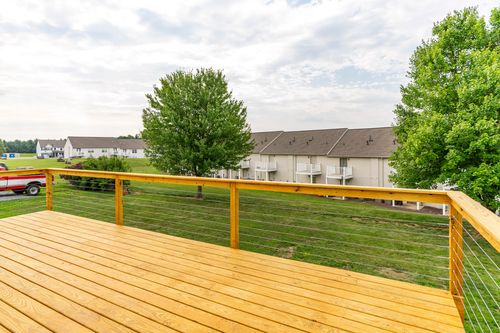Deck view over a cable railing looking out toward neighboring townhomes