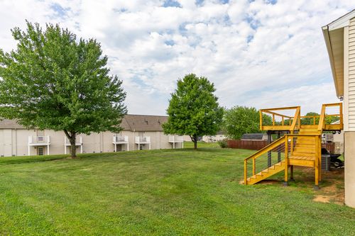 Backyard deck with cable railing and a staircase down to the lawn