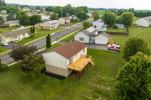 Aerial view of a home with an attached garage and pickup truck in the driveway