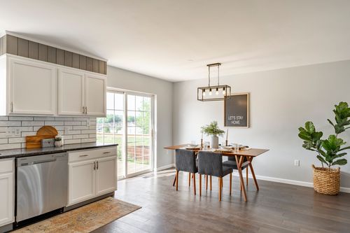 Kitchen with white cabinets, subway tile backsplash and an adjoining dining area