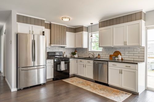 Kitchen with white cabinetry, subway tile backsplash and stainless appliances