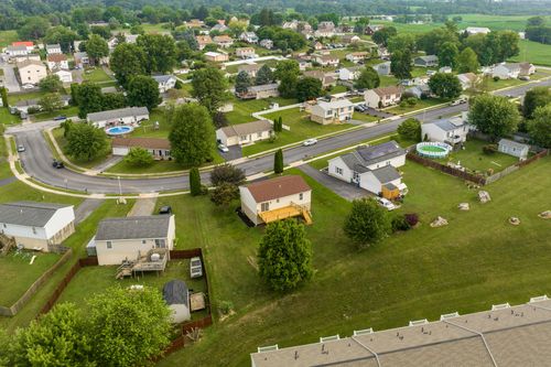 Aerial view of a raised home with an elevated deck in a residential neighborhood