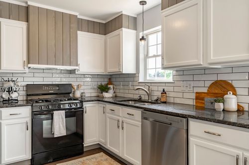 Kitchen corner with shiplap upper cabinets and a wood cutting board on the counter