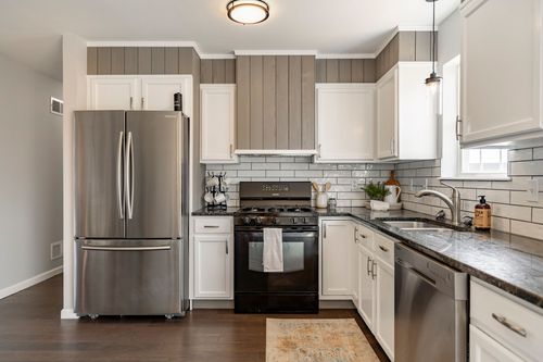 Kitchen with a stainless refrigerator, gas range and subway tile backsplash