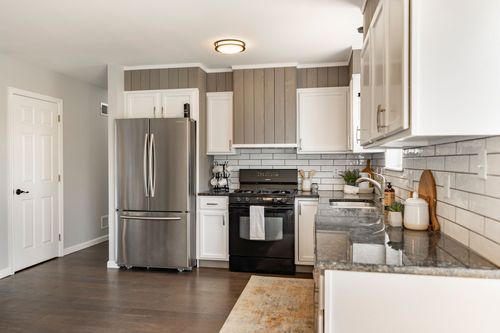 Kitchen with white cabinets, subway tile and stainless appliances