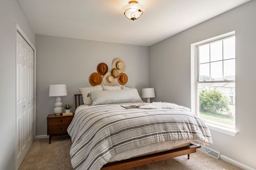 Bedroom with a display of hats above the headboard and mid-century nightstands