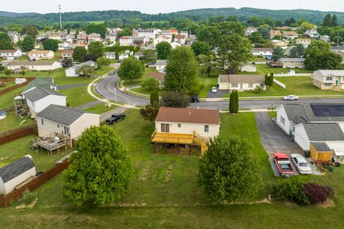 Aerial view of a home with a rear deck, surrounded by neighboring rooftops