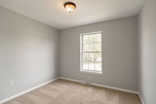 Empty bedroom with neutral carpet and a single window