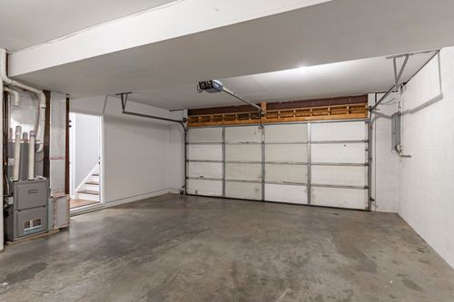 Empty garage with concrete flooring and a utility door