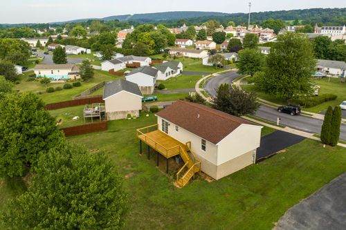 Aerial view of a home with a freshly built deck and manicured backyard