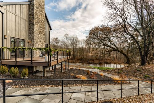 Elevated walkway along a wooded creek decorated with greenery garland