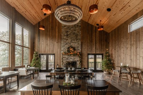 Stone fireplace decorated with a pine wreath and garland flanked by glass French doors