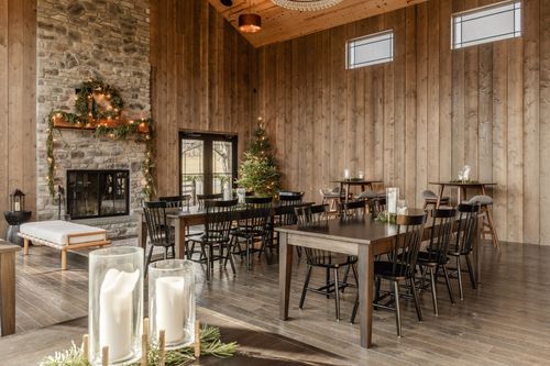 Wood-paneled room with tall glass doors, a lit Christmas tree and clerestory windows