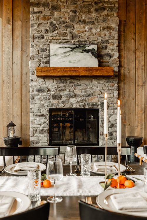 Stacked stone fireplace with a framed abstract painting and reclaimed wood mantel