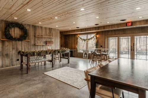 Rustic gathering room with a pine wreath, open shelving and a garland-draped serving table
