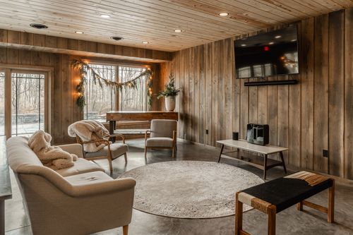Cozy sitting area with an upright piano, a neutral sofa and wall-mounted television