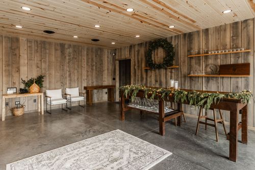Serving station with a pine wreath, garland-draped table and glass shelving