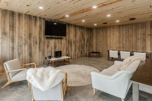 Living room with a round area rug, sherpa throw and wall-mounted television