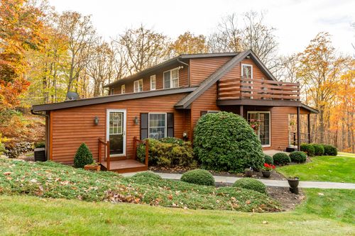 Log-style home front exterior with a covered entry and second-floor deck