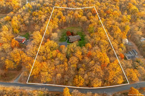 Aerial view of a wooded property boundary marked over a dense autumn forest lot