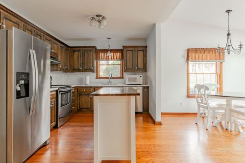 Kitchen with dark wood cabinets, stainless steel appliances and a white center island