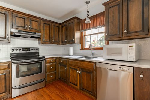 Kitchen peninsula with a white hutch and view through to an open living area