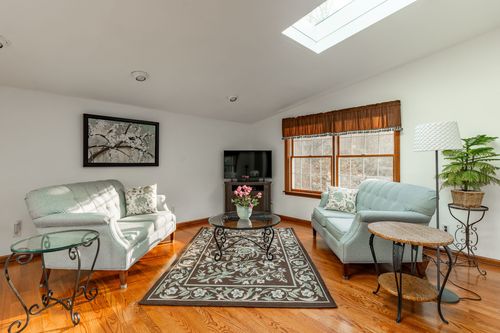 Living room with a wreathed entry door, sofa and floral centerpiece