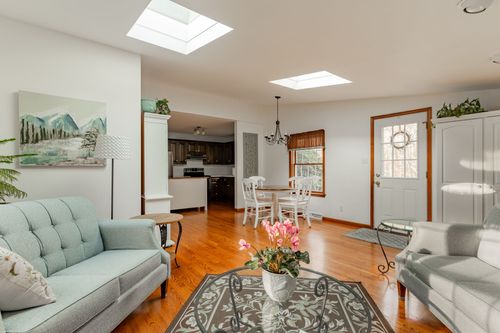 Dining nook with a white hutch, round table and chairs beside a kitchen