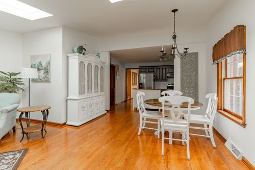 Formal dining room with a chandelier, curio cabinet and dark wood table set with chairs