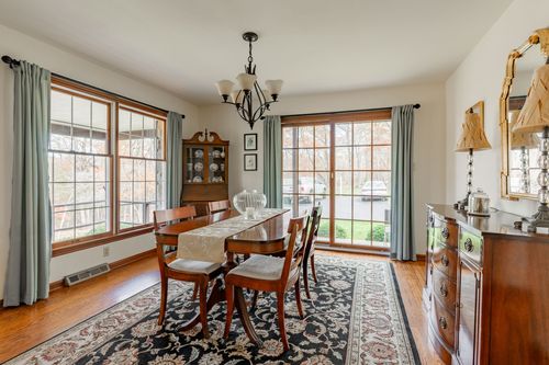 Dining room with a mahogany table set for six beneath a candelabra chandelier
