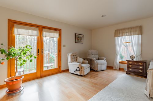 Primary bedroom with a writing desk, ceiling fan and a view into a walk-in closet