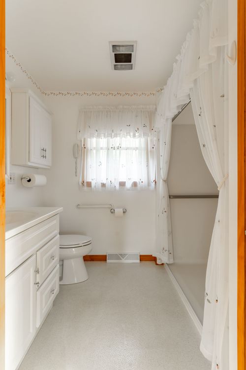 Bathroom with a white vanity, mirrored medicine cabinet and toilet