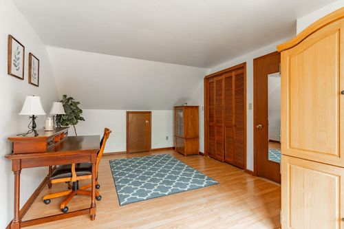 Bedroom with a louvered closet, wood armoire and patterned area rug