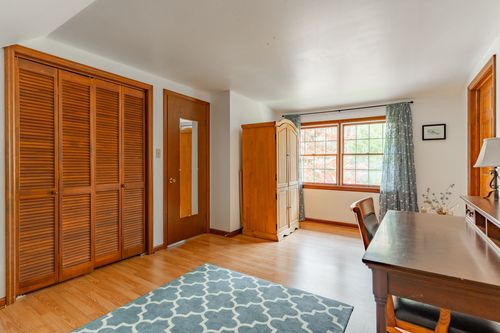 Bedroom with louvered wood closet doors and a blue geometric rug