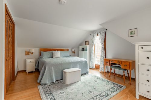 Bedroom with light blue bedding, matching nightstands and a louvered closet