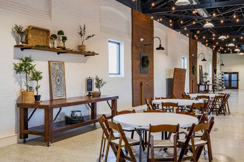 Banquet hall with wood accent walls, wreaths, and round tables set for a reception