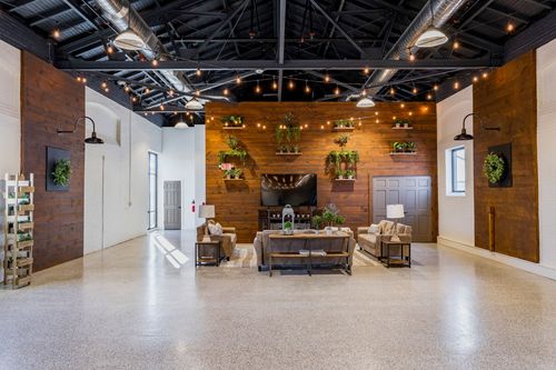 Wood pergola arbor with vertical planters and hanging greenery over round event tables