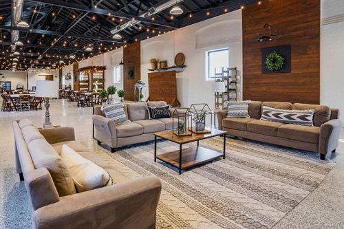 Lounge seating with sofas and a coffee table beside a wood accent wall and display shelf