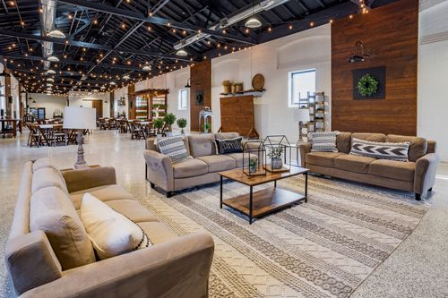 Lounge area with sofas, a coffee table, and a wood accent wall near a dining setup