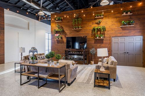 Lounge area with a reclaimed wood wall, mounted TV, hanging planters, and sectional seating
